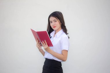 Taylandlı yetişkin üniversite üniforması güzel kız kırmızı kitabı okuyor.