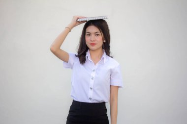 Taylandlı yetişkin üniversite üniforması güzel kız kırmızı kitabı okuyor.