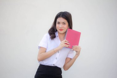Taylandlı yetişkin öğrenci üniforması güzel kız kırmızı kitap gösteriyor.