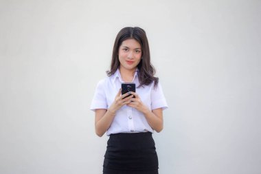 Yetişkin öğrenci üniforması. Akıllı telefonunu kullanan güzel bir kız.