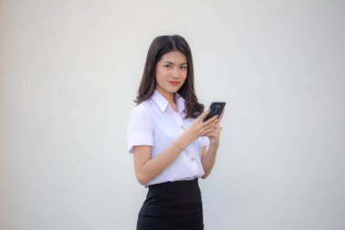 Yetişkin öğrenci üniforması. Akıllı telefonunu kullanan güzel bir kız.