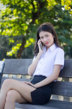 Taylandlı yetişkin öğrenci üniforması güzel kız rahatla ve gülümse.