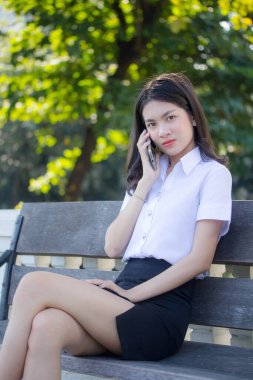 Taylandlı yetişkin öğrenci üniforması güzel kız rahatla ve gülümse.