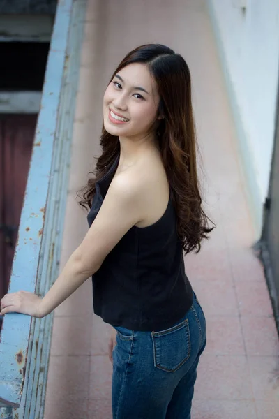 차이나 성인의 아름다운 소녀검은 셔츠푸른 청바지가 긴장을 미소를 — 스톡 사진