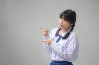 Taylandlı liseli üniformasının portresi. Güzel bir kız işaret ediyor.