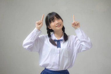 Taylandlı liseli üniformasının portresi. Güzel bir kız işaret ediyor.