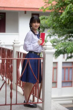 Taylandlı liseli üniforması genç güzel kız mutlu ve rahat