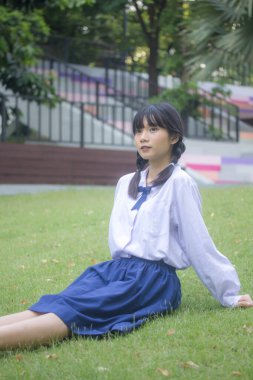 Taylandlı liseli üniformasının portresi. Genç güzel kız mutlu ve rahat.