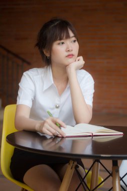 Taylandlı yetişkin öğrenci üniformasının portresi. Güzel kız. Kitap yaz.