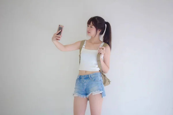 美しいですタイの女の子観光客スコティッシュホワイトシャツブルージーンズ使用して彼女のスマートフォンSelfie — ストック写真