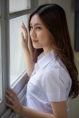 Taylandlı yetişkin öğrenci üniforması güzel kız rahatla ve gülümse.