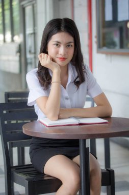 Taylandlı yetişkin öğrenci üniforması güzel kız rahatla ve gülümse.