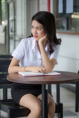 Taylandlı yetişkin öğrenci üniforması güzel kız rahatla ve gülümse.