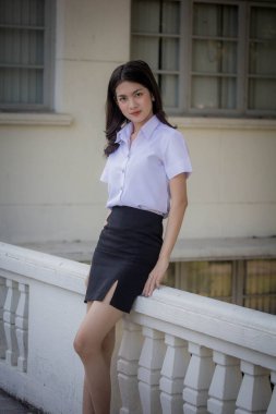 Taylandlı yetişkin öğrenci üniforması güzel kız rahatla ve gülümse.