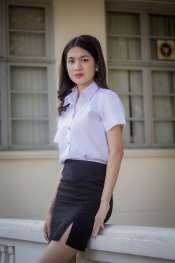 Taylandlı yetişkin öğrenci üniforması güzel kız rahatla ve gülümse.