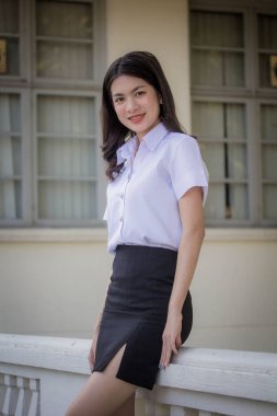 Taylandlı yetişkin öğrenci üniforması güzel kız rahatla ve gülümse.