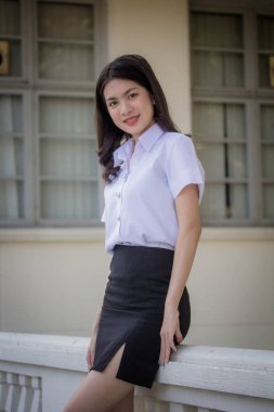 Taylandlı yetişkin öğrenci üniforması güzel kız rahatla ve gülümse.