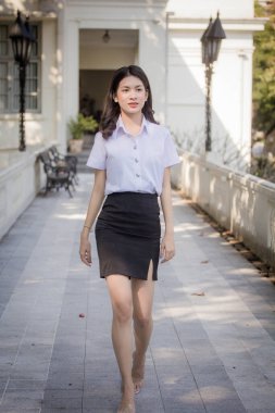 Taylandlı yetişkin öğrenci üniforması güzel kız rahatla ve gülümse.