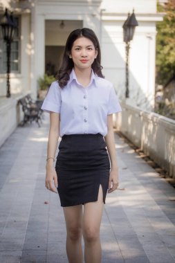 Taylandlı yetişkin öğrenci üniforması güzel kız rahatla ve gülümse.