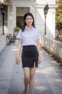 Taylandlı yetişkin öğrenci üniforması güzel kız rahatla ve gülümse.