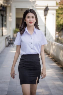 Taylandlı yetişkin öğrenci üniforması güzel kız rahatla ve gülümse.