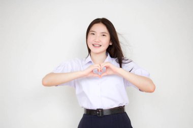 Taylandlı liseli üniformasının portresi. Güzel bir kız kalbini verir.