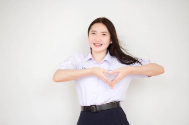 Taylandlı liseli üniformasının portresi. Güzel bir kız kalbini verir.