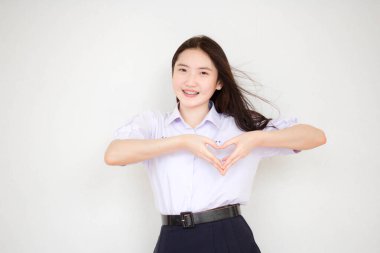 Taylandlı liseli üniformasının portresi. Güzel bir kız kalbini verir.