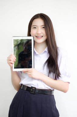 Portrait of thai high school student uniform beautiful girl using her tablet.