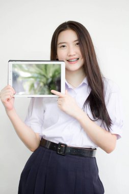 Portrait of thai high school student uniform beautiful girl using her tablet.