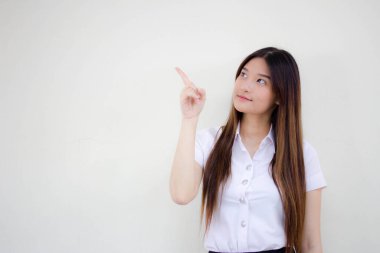 Taylandlı yetişkin öğrenci üniformasının portresi. Güzel bir kız işaret ediyor.