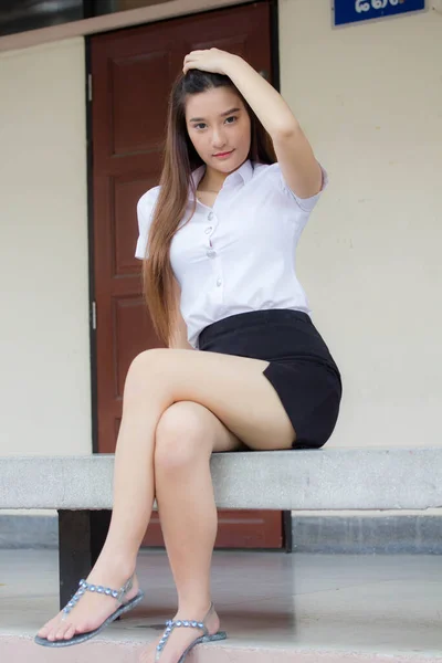 Taylandlı yetişkin öğrenci üniforması portresi. Güzel kız rahatla ve gülümse.