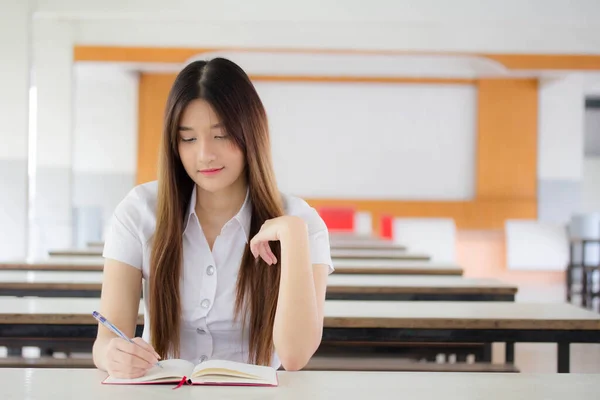 泰族成人大学生校服漂亮女孩读红皮书的肖像 — 图库照片