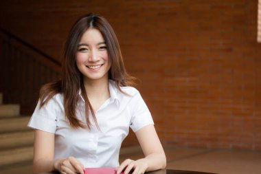 Taylandlı yetişkin öğrenci üniforması portresi. Güzel kız rahatla ve gülümse.