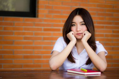 Taylandlı yetişkin öğrenci üniforması portresi. Güzel kız rahatla ve gülümse.