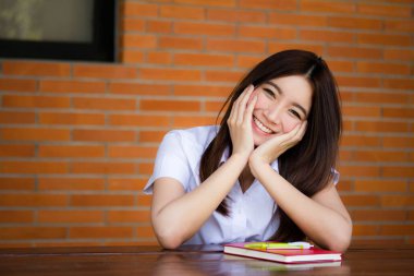 Taylandlı yetişkin öğrenci üniforması portresi. Güzel kız rahatla ve gülümse.