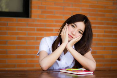 Taylandlı yetişkin öğrenci üniforması portresi. Güzel kız rahatla ve gülümse.