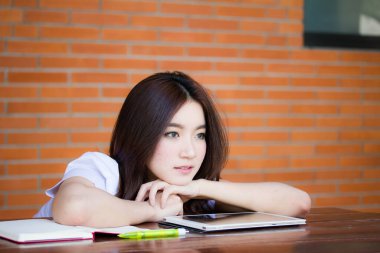 Taylandlı yetişkin öğrenci üniforması portresi. Güzel kız rahatla ve gülümse.