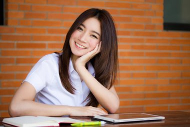 Taylandlı yetişkin öğrenci üniforması portresi. Güzel kız rahatla ve gülümse.