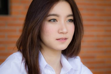 Taylandlı yetişkin öğrenci üniforması portresi. Güzel kız rahatla ve gülümse.