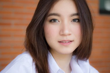 Taylandlı yetişkin öğrenci üniforması portresi. Güzel kız rahatla ve gülümse.