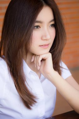 Taylandlı yetişkin öğrenci üniforması portresi. Güzel kız rahatla ve gülümse.