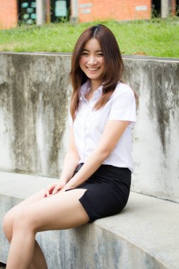 Taylandlı yetişkin öğrenci üniforması portresi. Güzel kız rahatla ve gülümse.