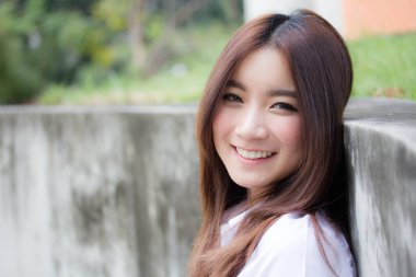 Taylandlı yetişkin öğrenci üniforması portresi. Güzel kız rahatla ve gülümse.