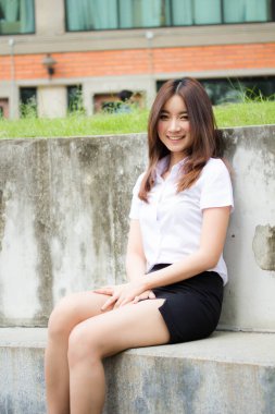 Taylandlı yetişkin öğrenci üniforması portresi. Güzel kız rahatla ve gülümse.