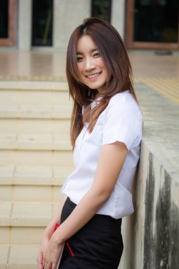 Taylandlı yetişkin öğrenci üniforması portresi. Güzel kız rahatla ve gülümse.