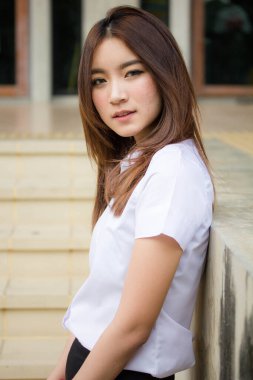 Taylandlı yetişkin öğrenci üniforması portresi. Güzel kız rahatla ve gülümse.