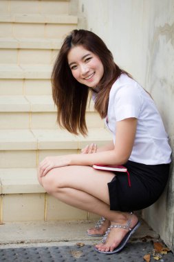 Taylandlı yetişkin öğrenci üniforması portresi. Güzel kız rahatla ve gülümse.