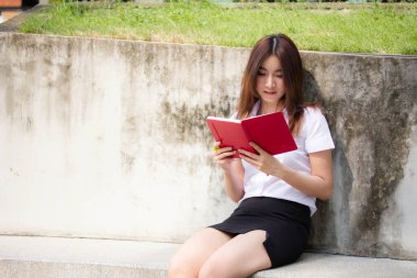 Taylandlı yetişkin öğrenci üniforması portresi. Güzel kız kırmızı kitabı okudu.