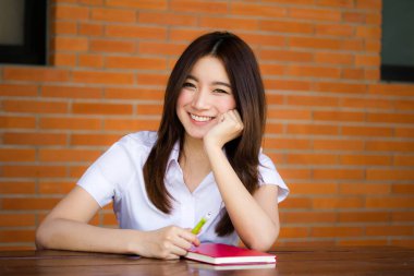 Taylandlı yetişkin öğrenci üniformasının portresi. Güzel kız. Kitap yaz.